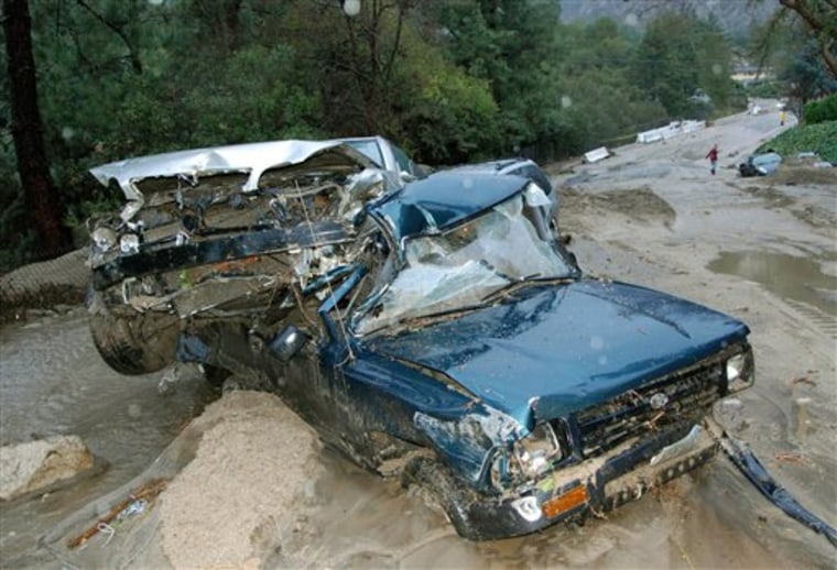 Two cars sit damaged by flood waters and mud on Ocean View Boulevard in La Canada Flintridge, Calif., on Saturday.